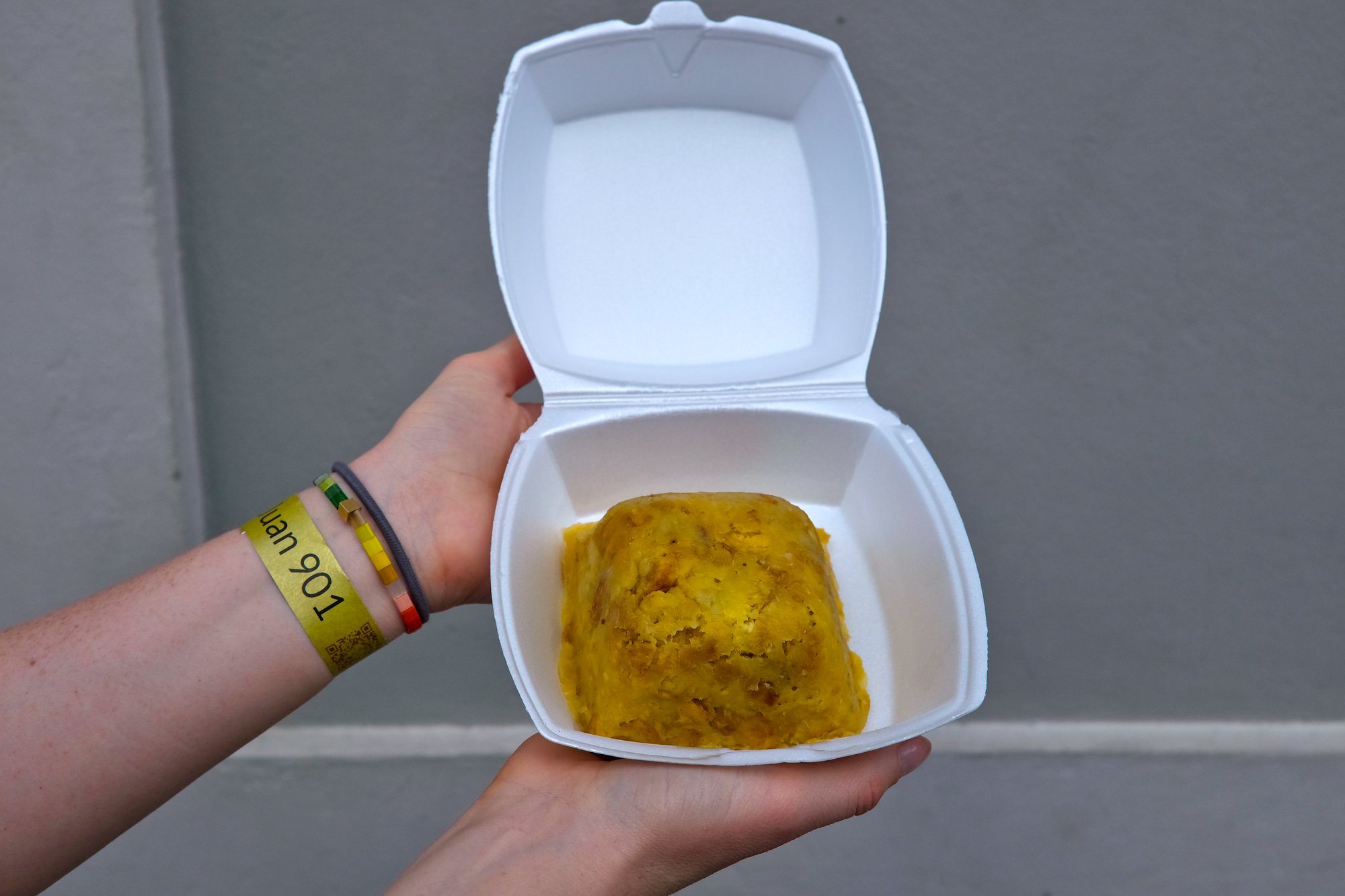 Alyssa holds up a takeout tray of mofongo