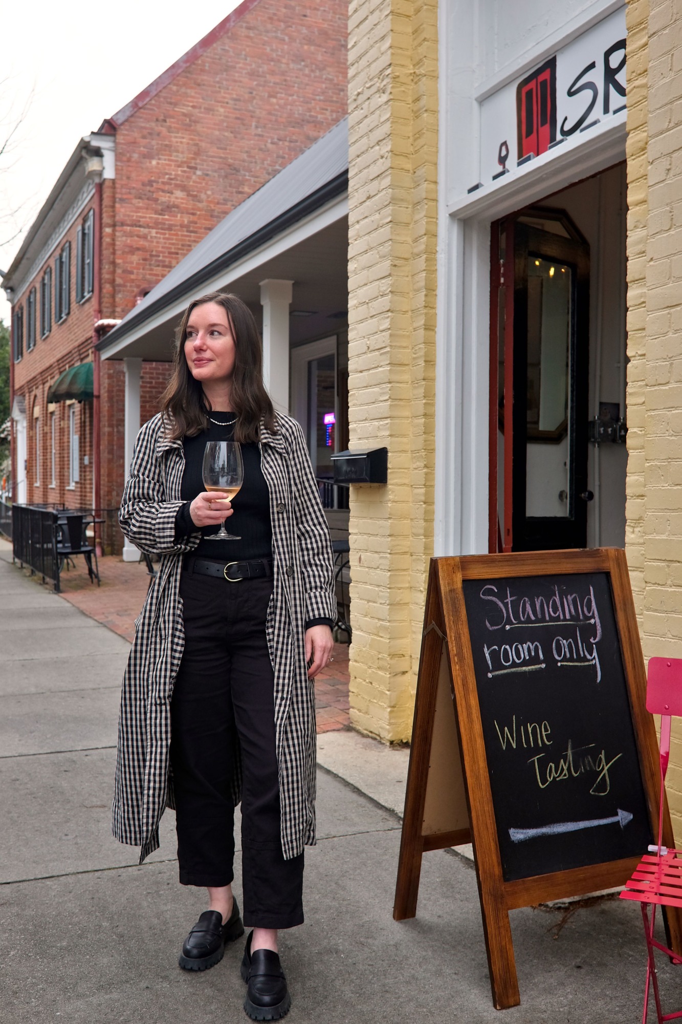 Alyssa holds a wine glass outside of Standing Room Only