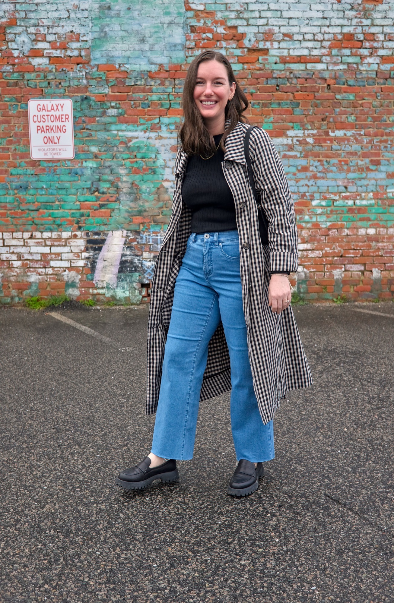 Alyssa wears a black top with blue jeans and loafers