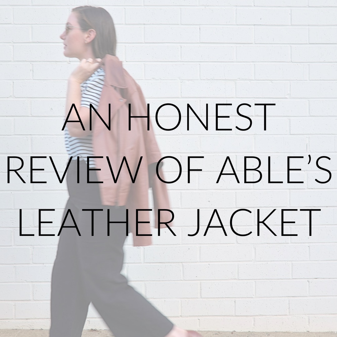 Alyssa walks carrying a jacket and text overlay reads "an honest review of ABLE's leather jacket"