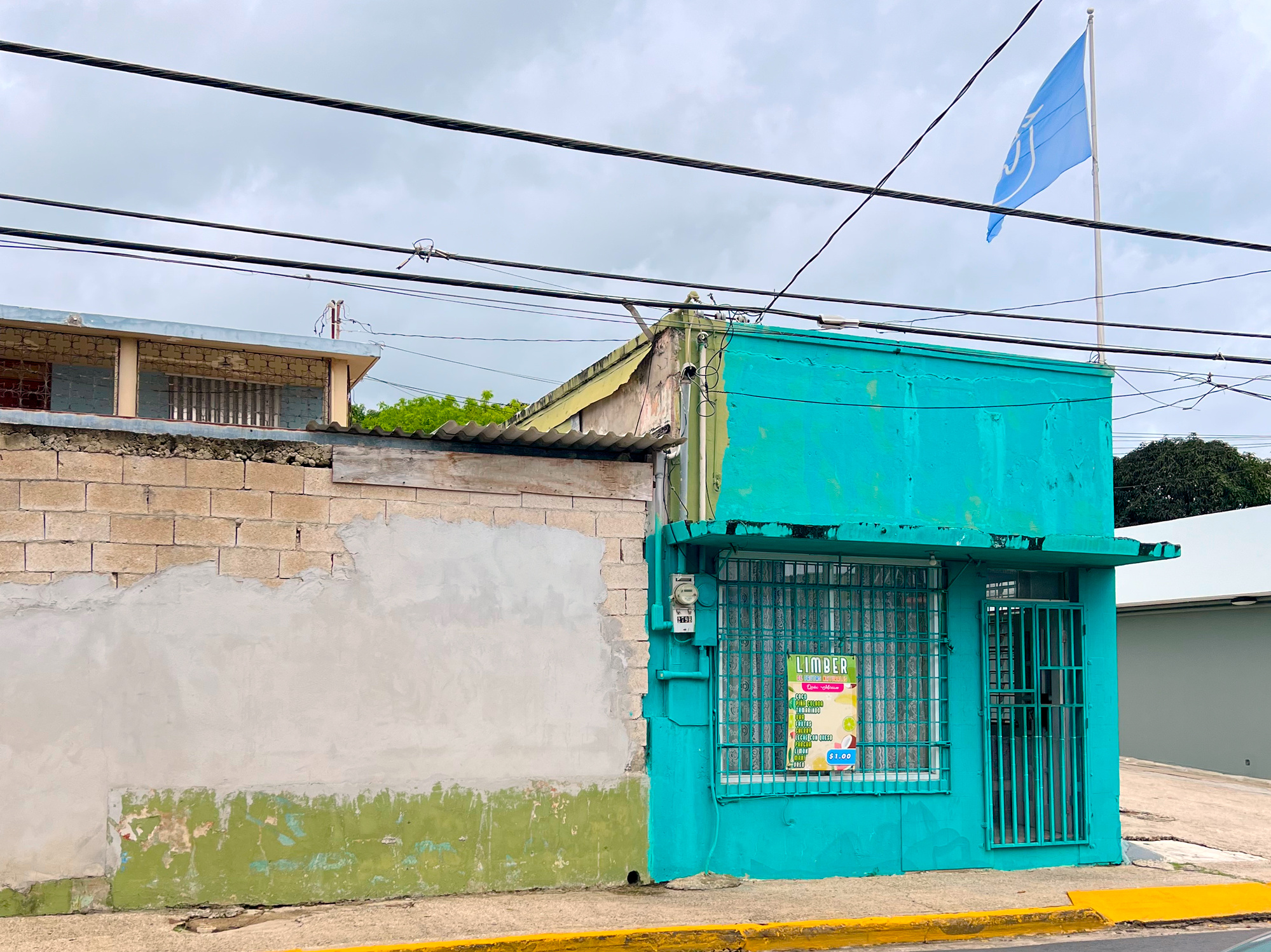 Outside of a vibrant blue house advertising Limber for $1