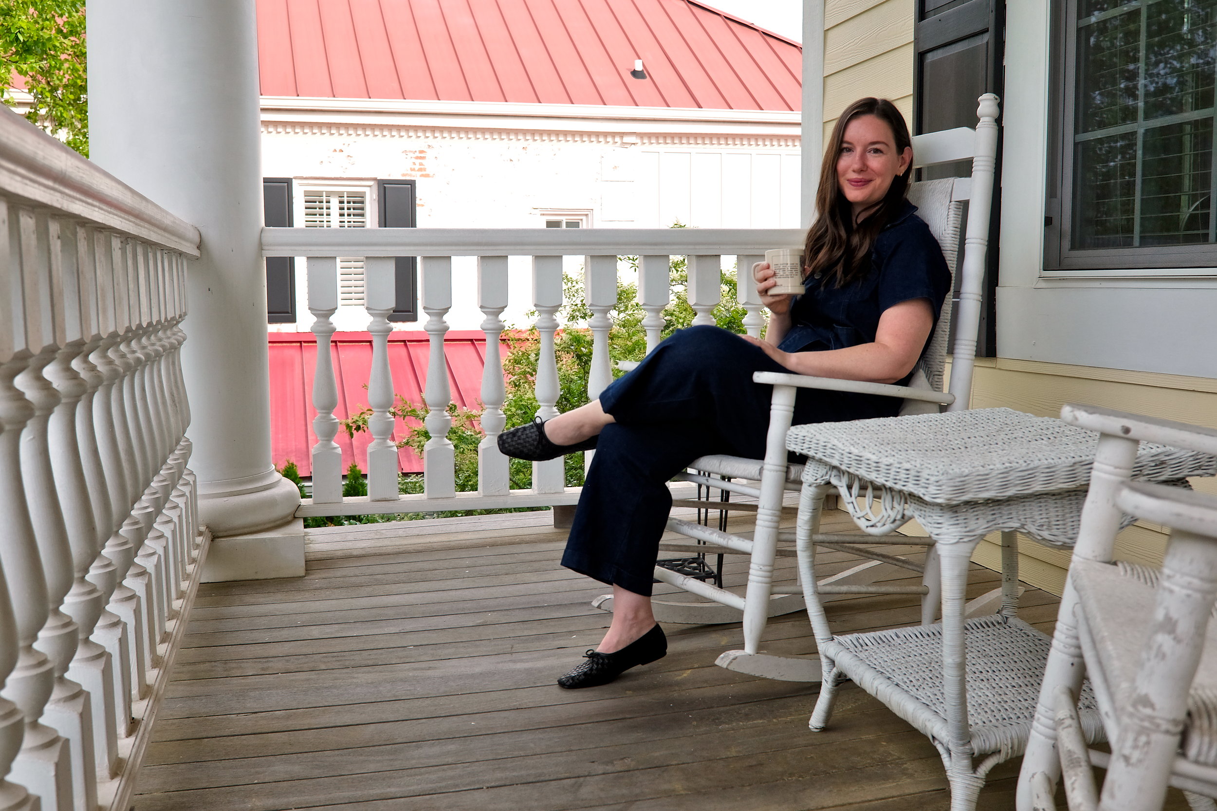 Alyssa sits in a rocking chair on the veranda