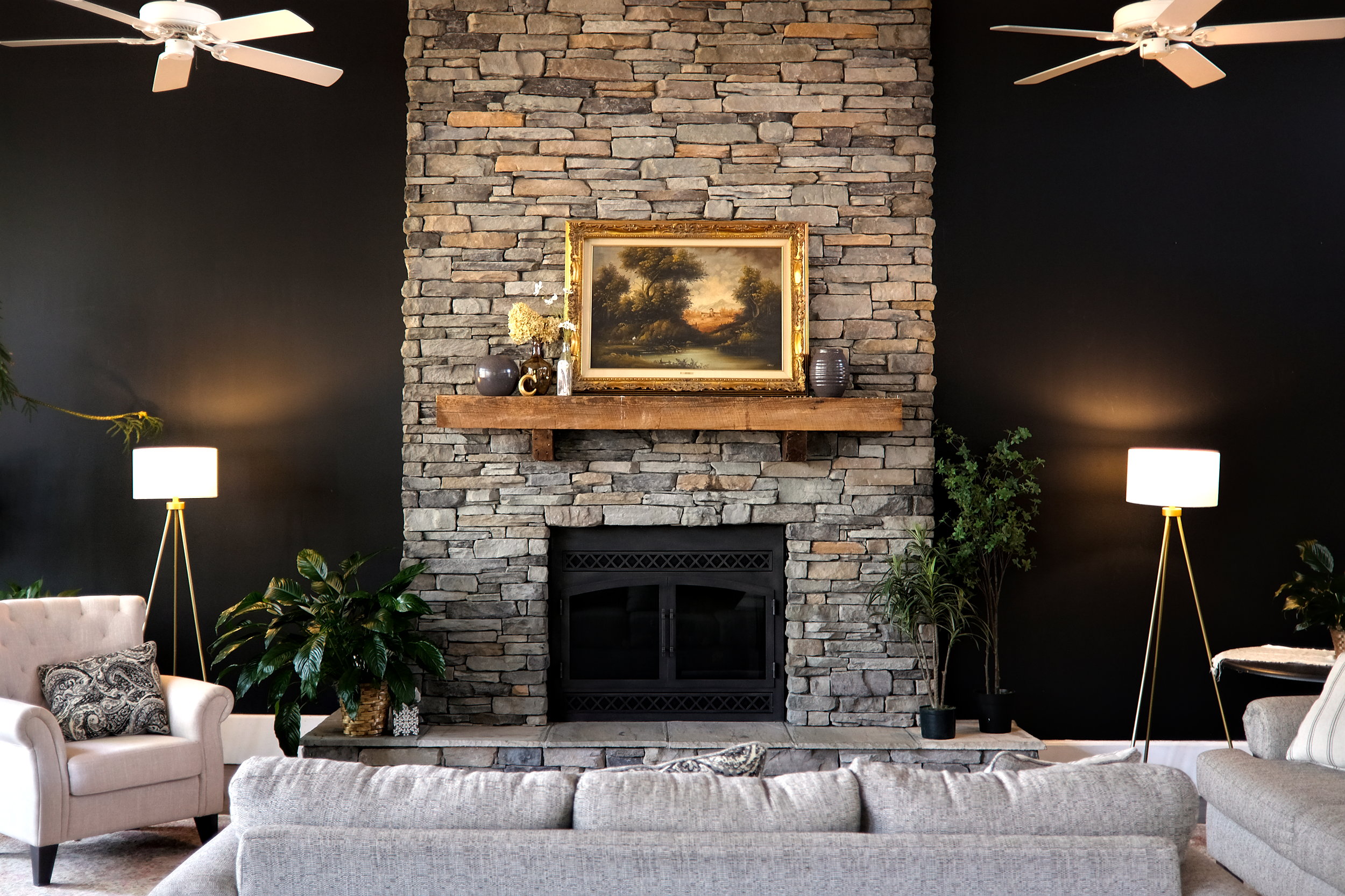 The living room at Sharon Manor, with a fireplace, sofa, and ceiling fans