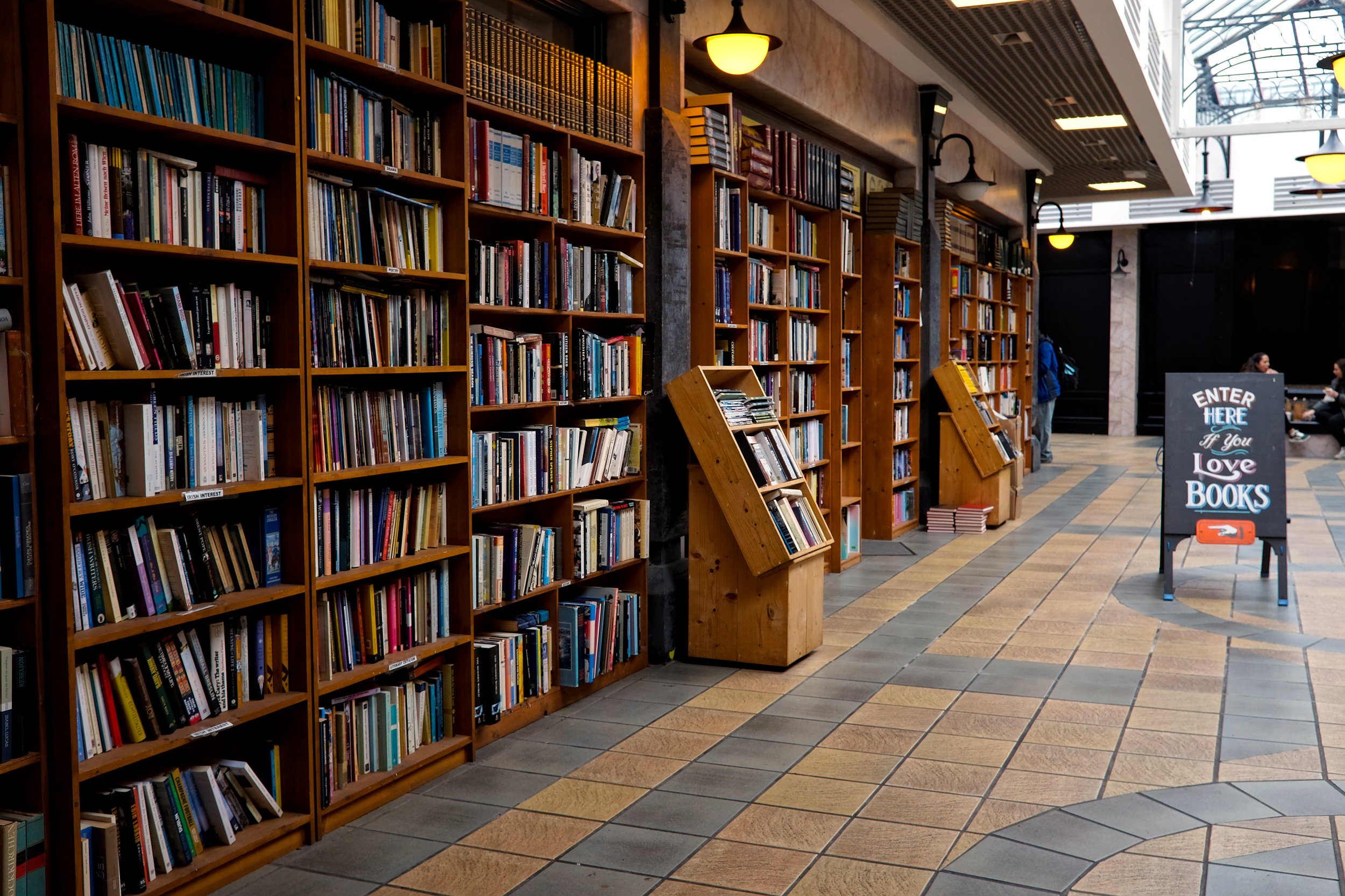 Entrance to the cozy and eclectic Charlie Byrne’s Bookshop in Galway, with tall wooden bookshelves packed with new and secondhand books.