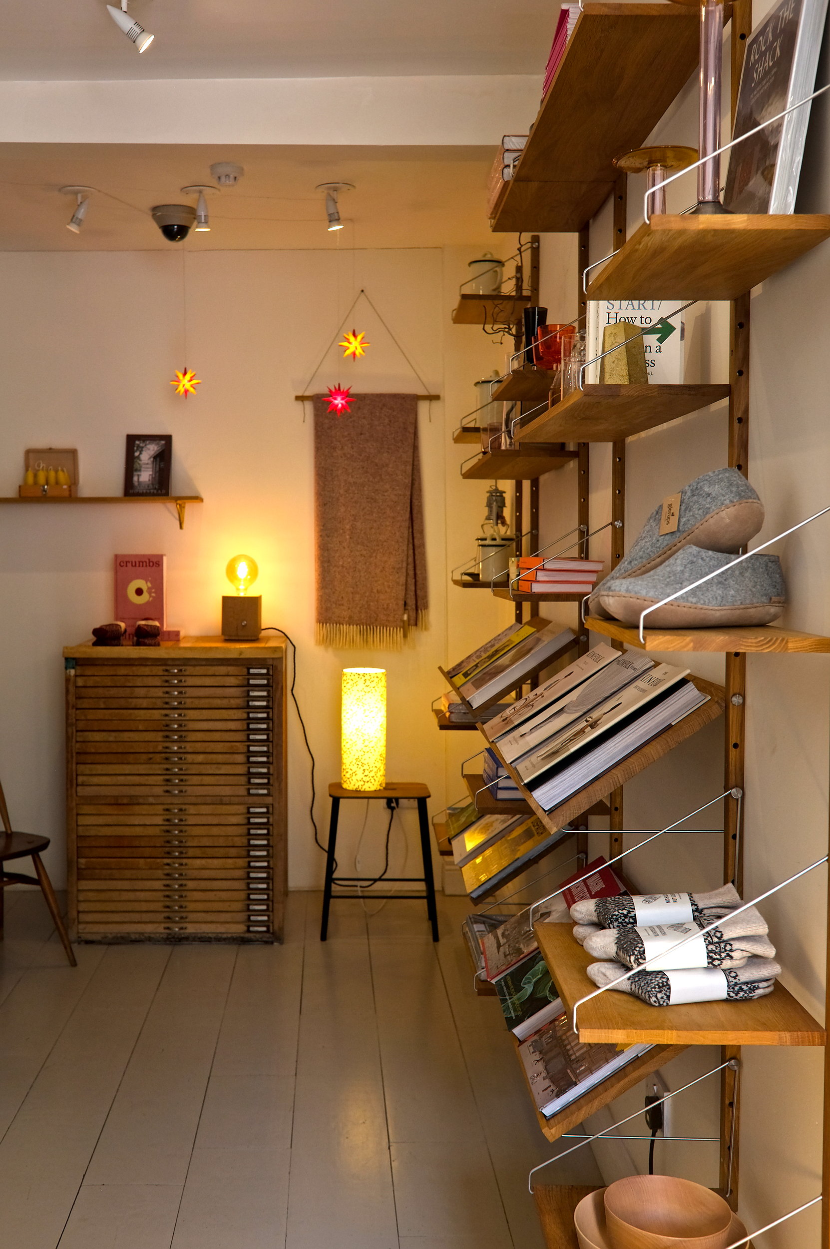 Interior of the shop area at Coffeewerk + Press featuring curated lifestyle goods, art prints, and design books displayed on sleek shelves, blending retail and café aesthetics in a modern, airy space.