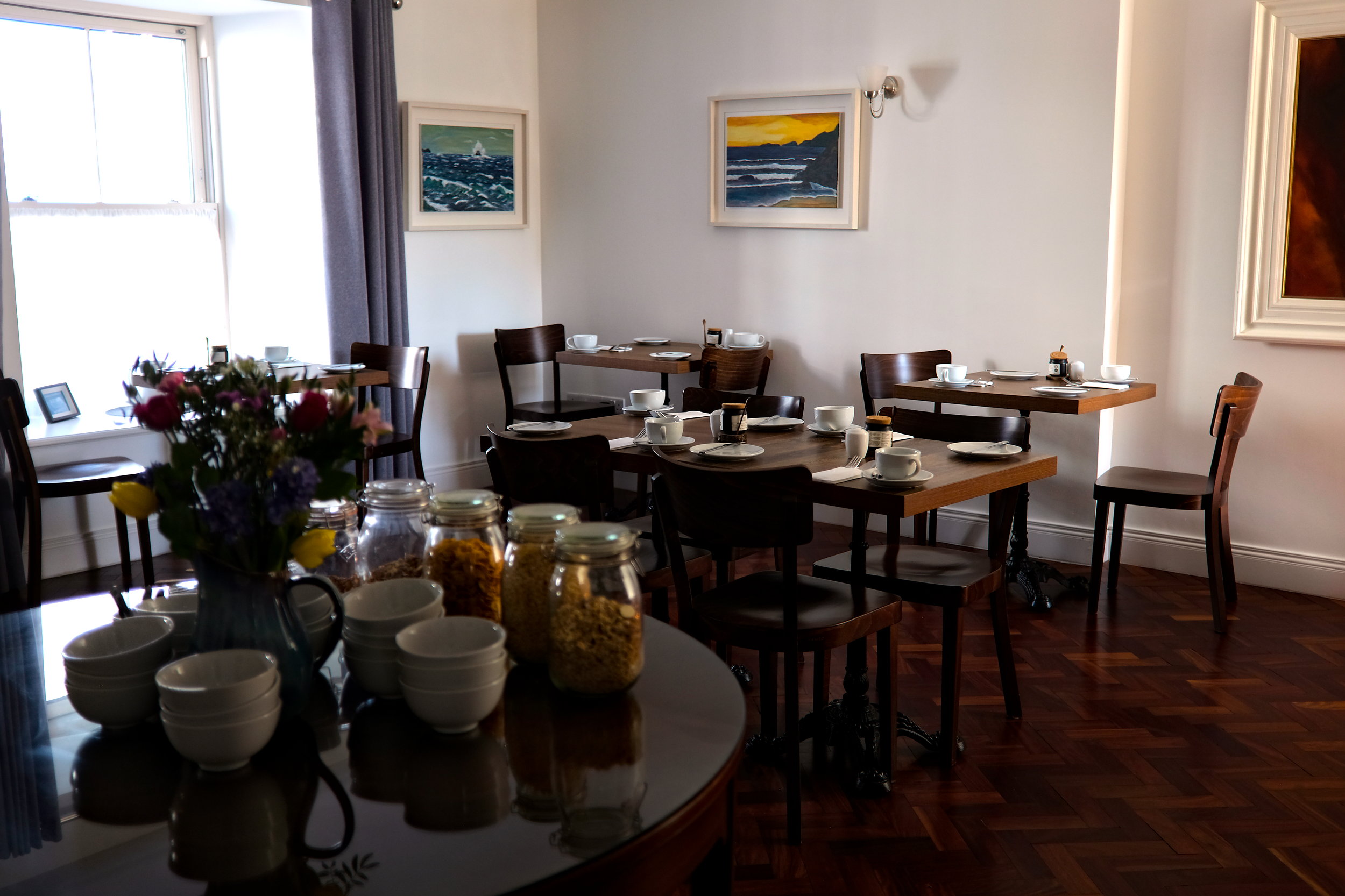 Inviting breakfast room with natural light pouring in, neatly set tables, and a warm, relaxed atmosphere perfect for a morning meal.