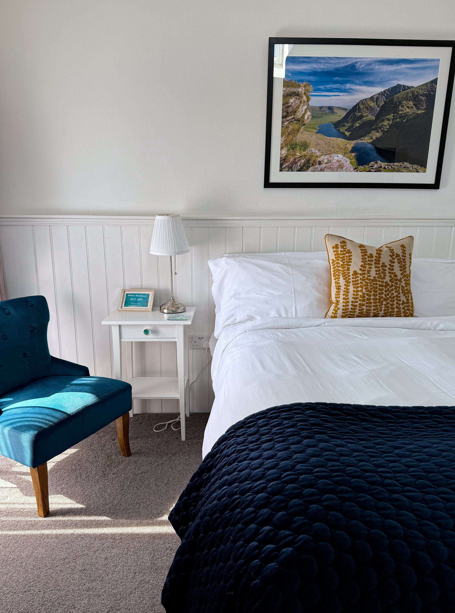 Spacious guest room with a plush king-size bed dressed in crisp white linens, accented by soft lighting and modern, minimal decor.