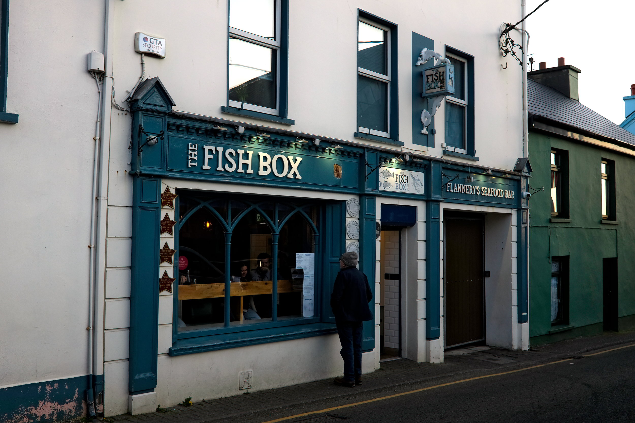 A person looks in the window at The Fish Box in Dingle, Ireland