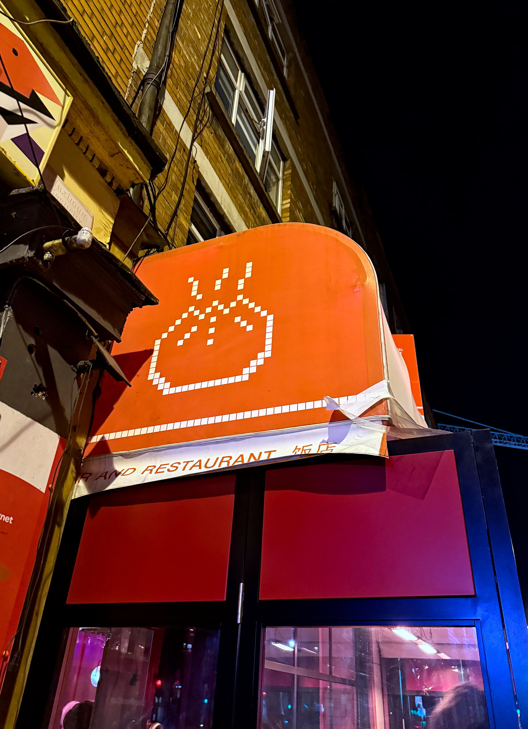 An orange awning with a pixelated dumpling art at BIGFAN in Dublin