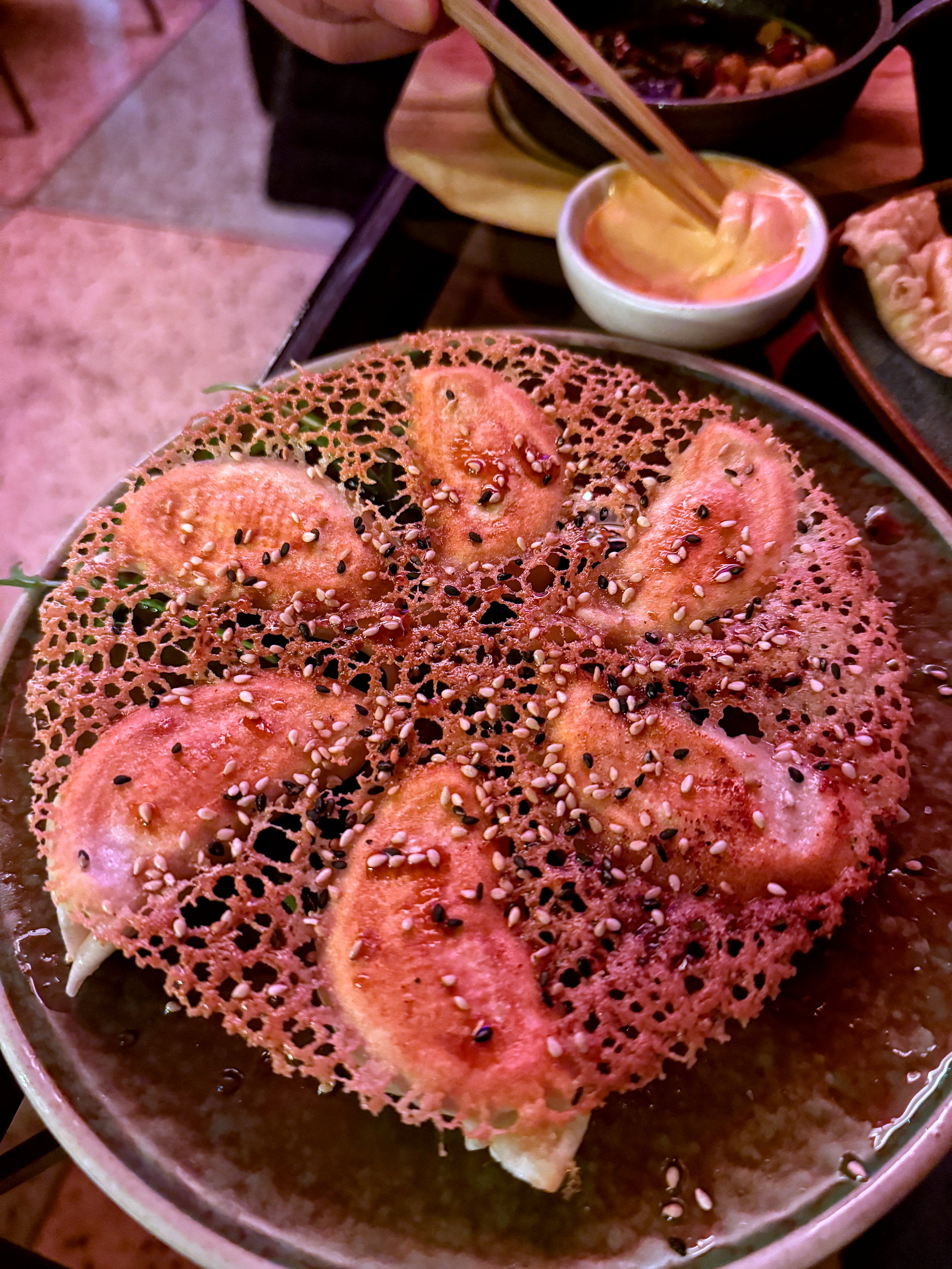 A plate of dumplings with a lacy, crisp edge surrounding them at BIGFAN