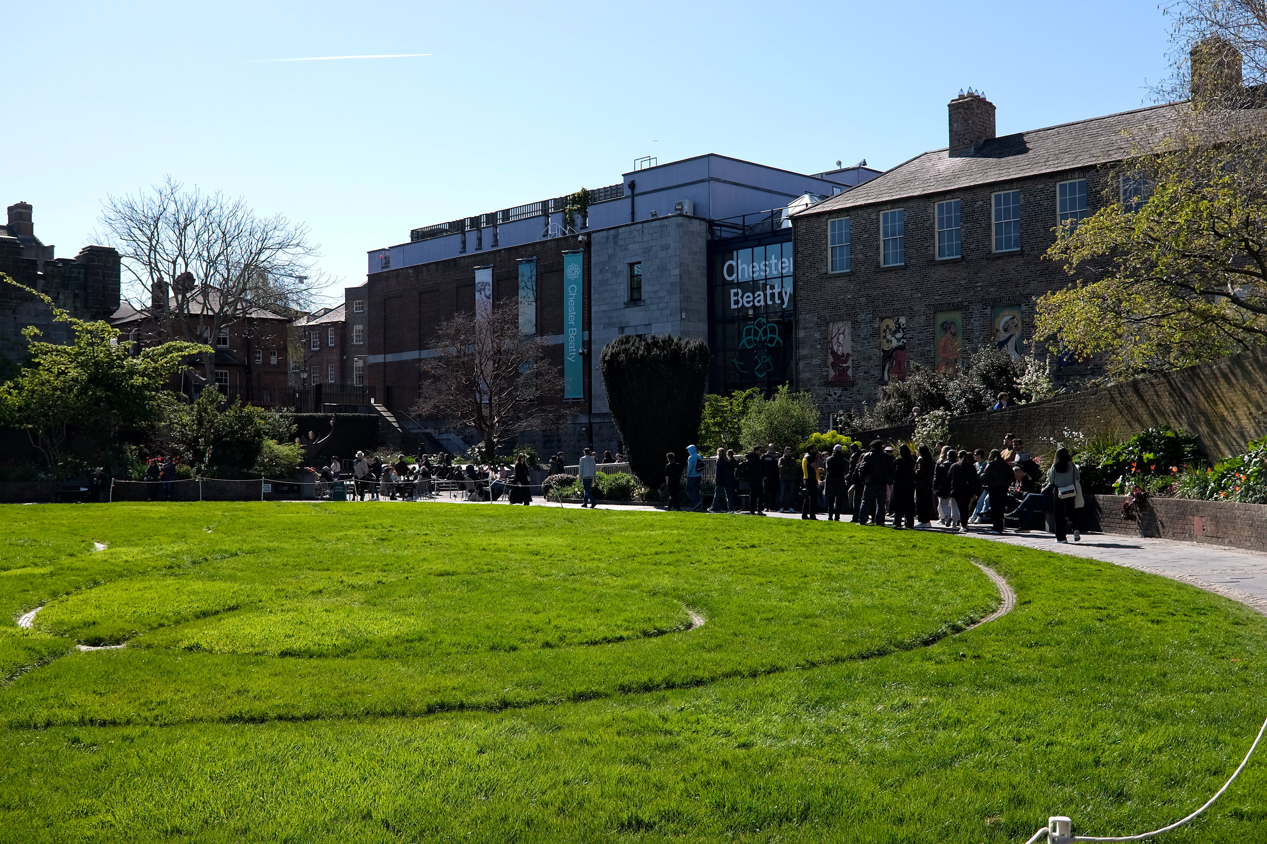 A crowd of people circle the walkway in front of Chester Beatty Library in Dublin