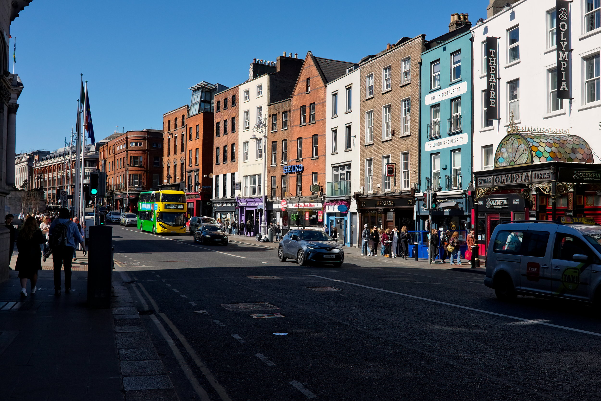 A busy street with buses, cars, people in Dublin