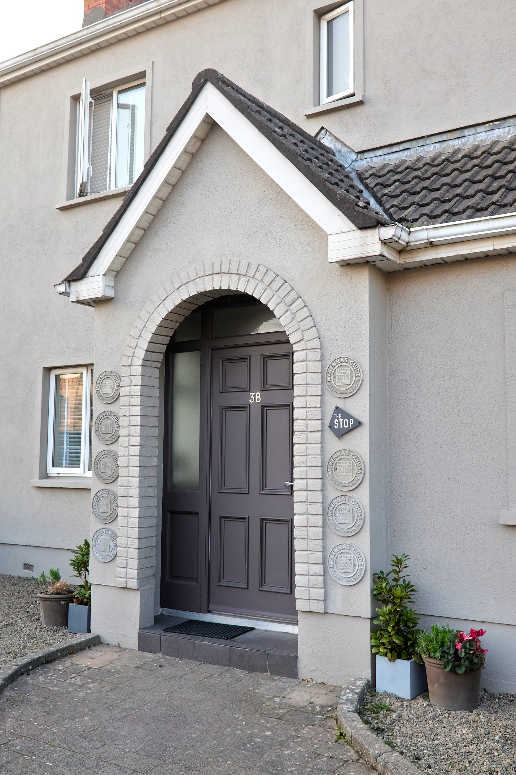 The exterior of The Stop in Galway, with a grey exterior and awards lining the front door