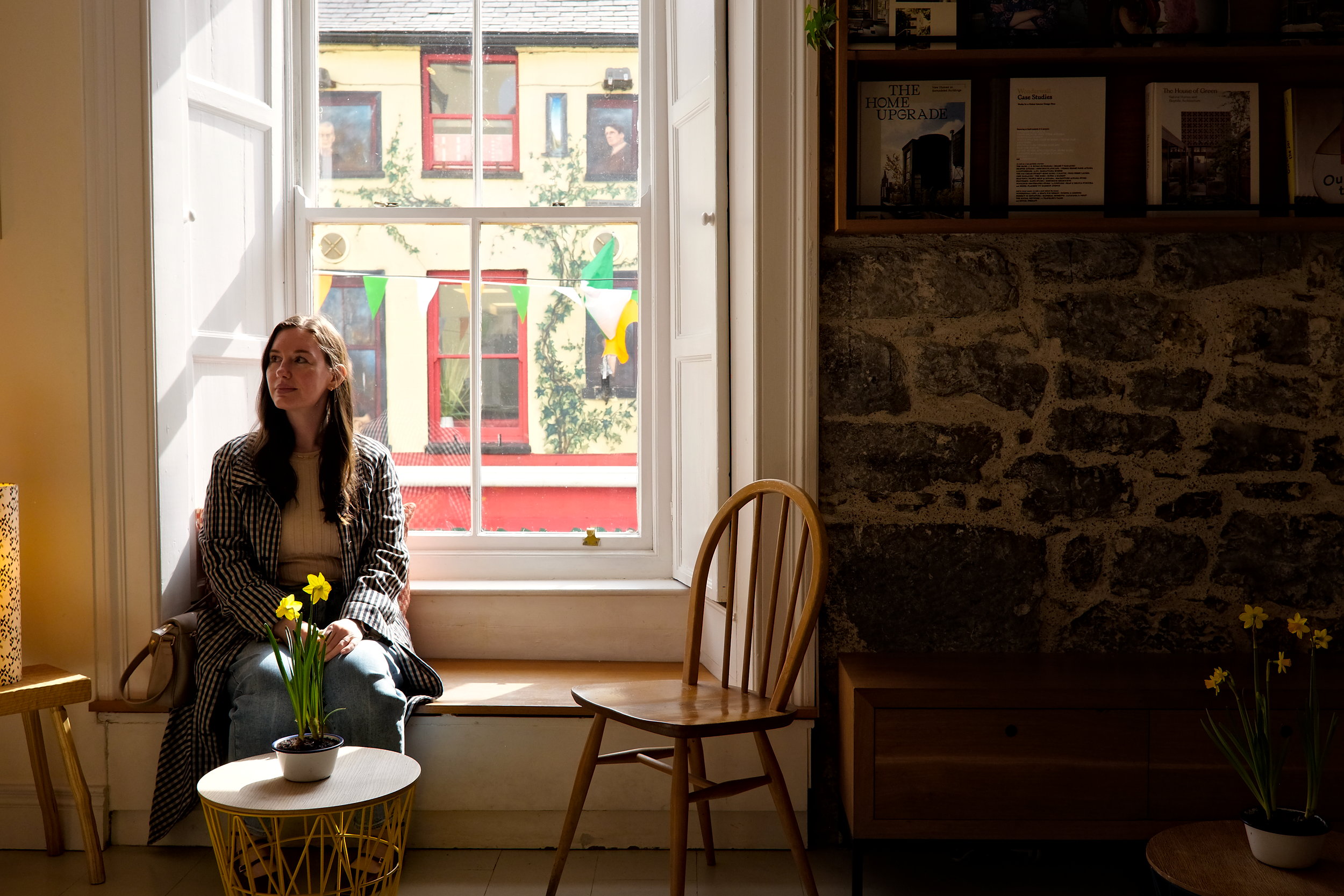 Alyssa sits in a coffee shop window seat in Galway