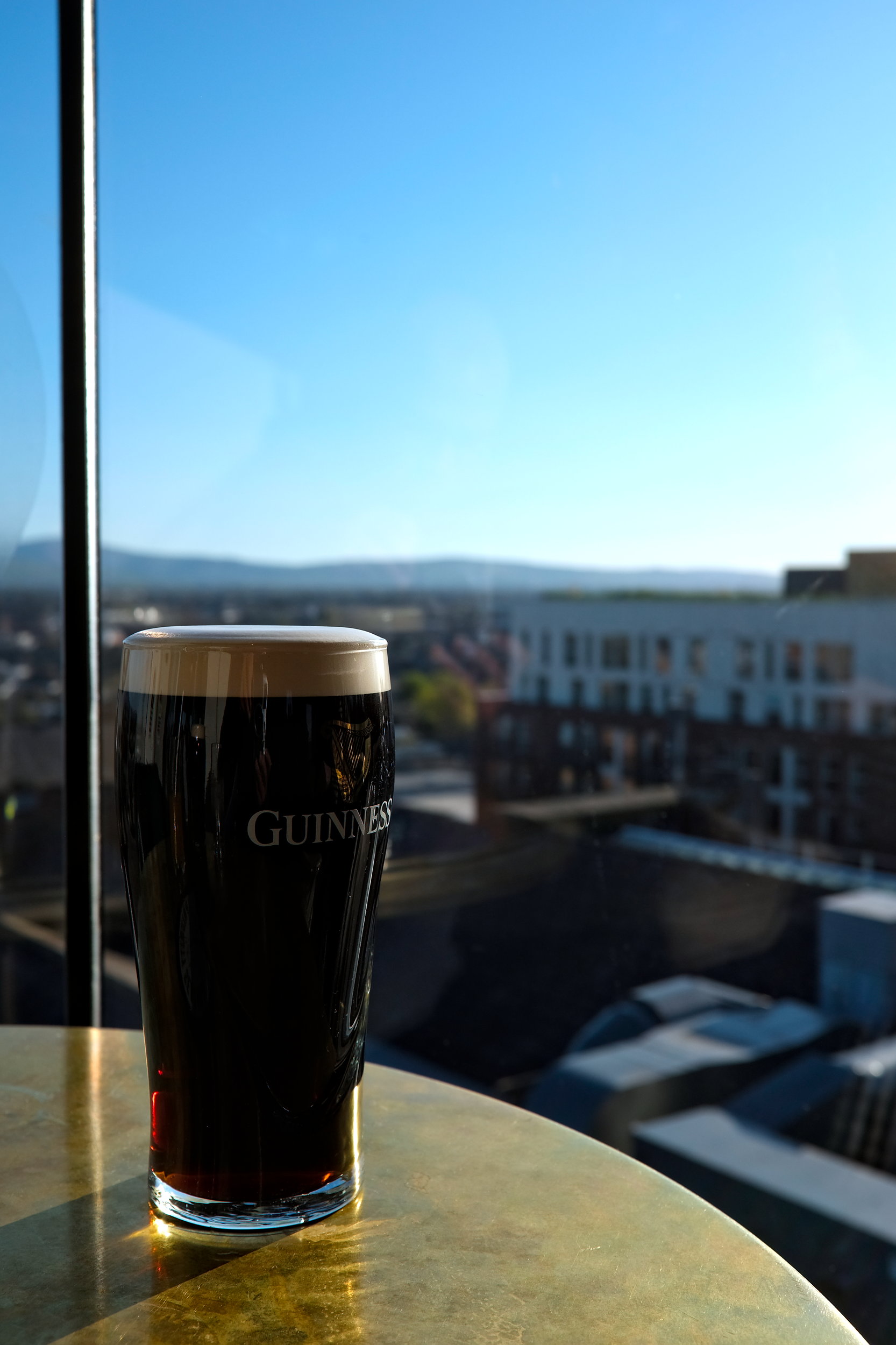 A pint of Guinness with the city in the background