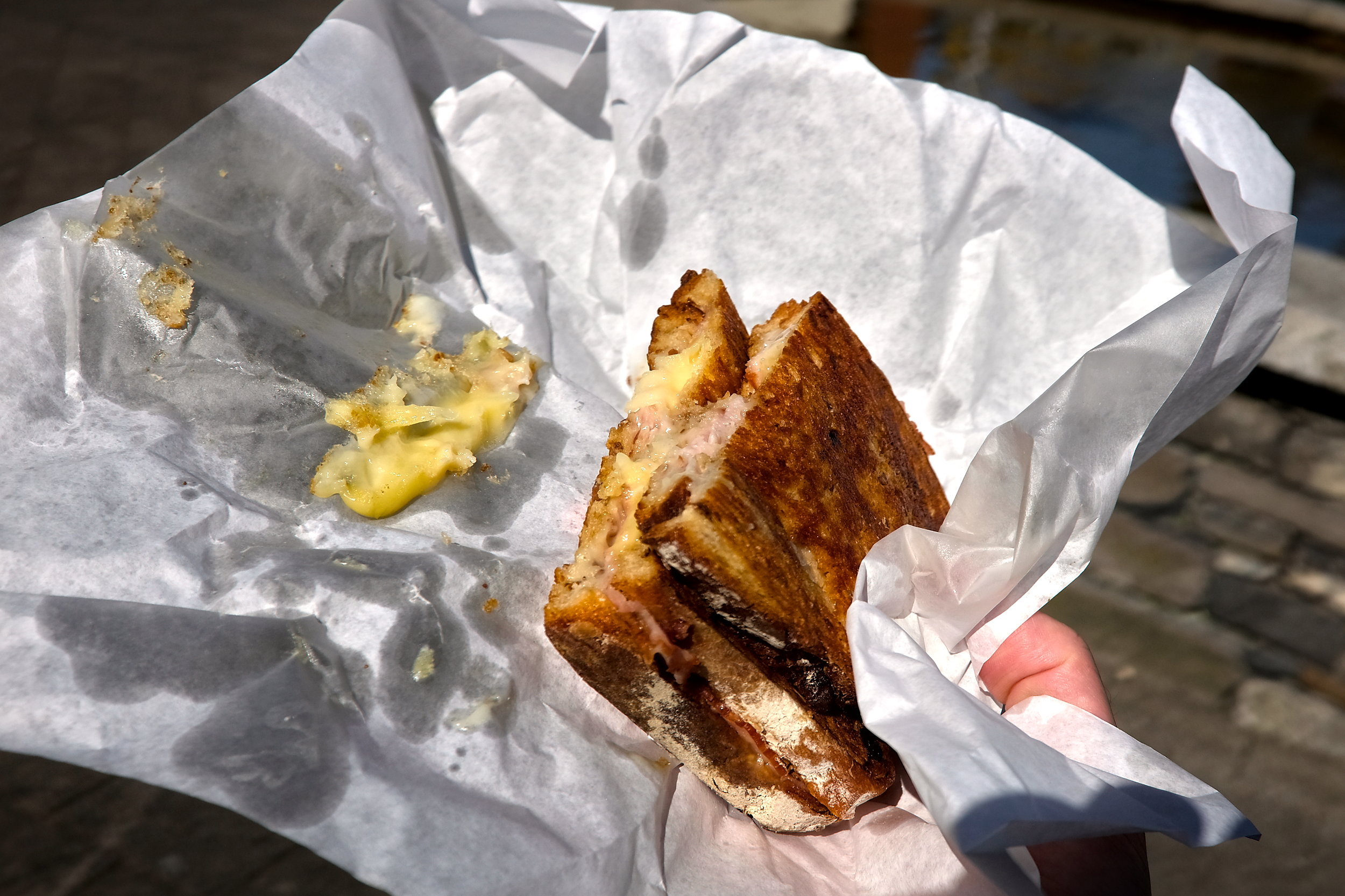 A ham and cheese toastie wrapped in paper from Loose Canon Cheese and Wine