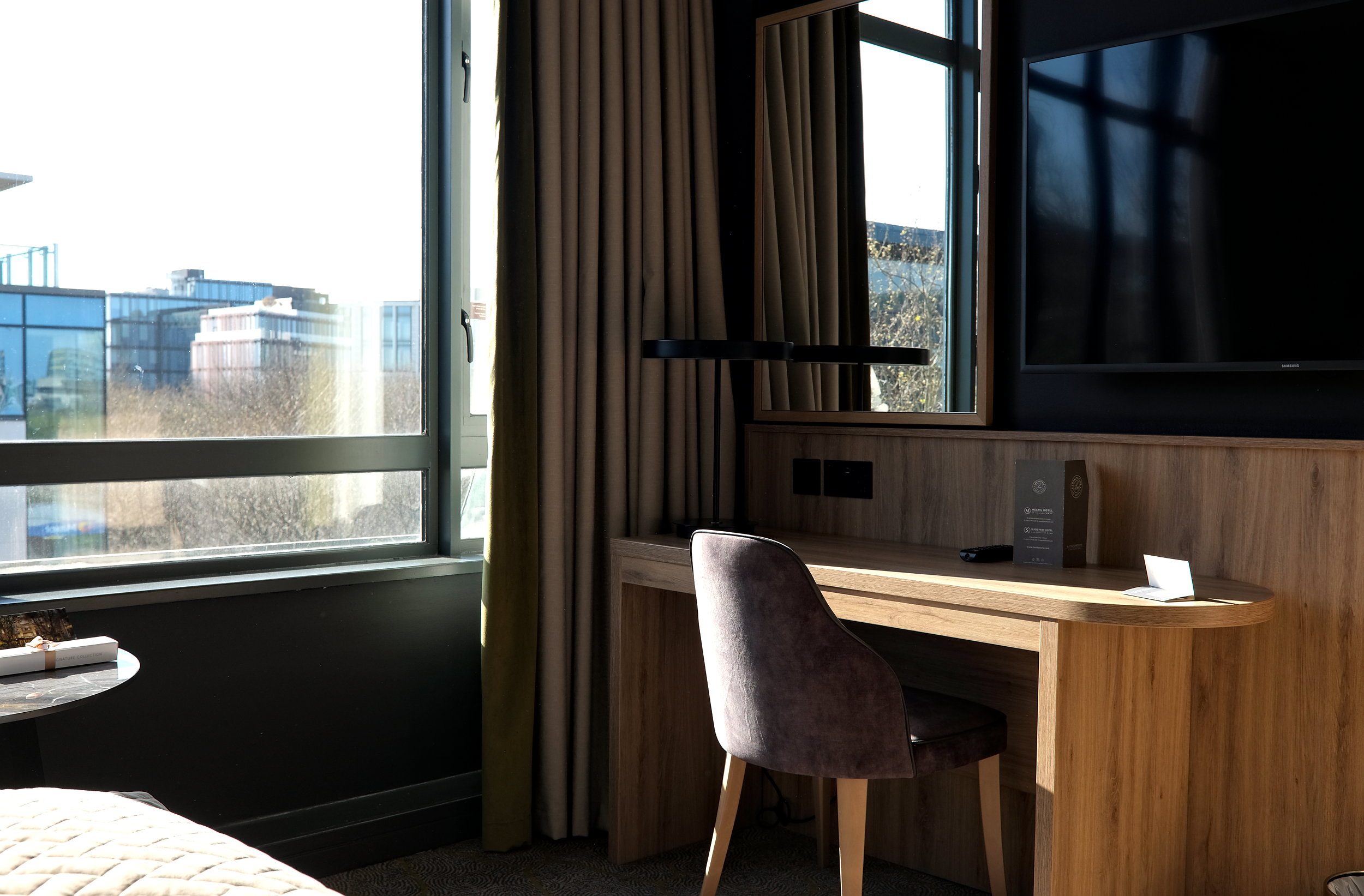 A desk with a big TV above it at Mespil Hotel