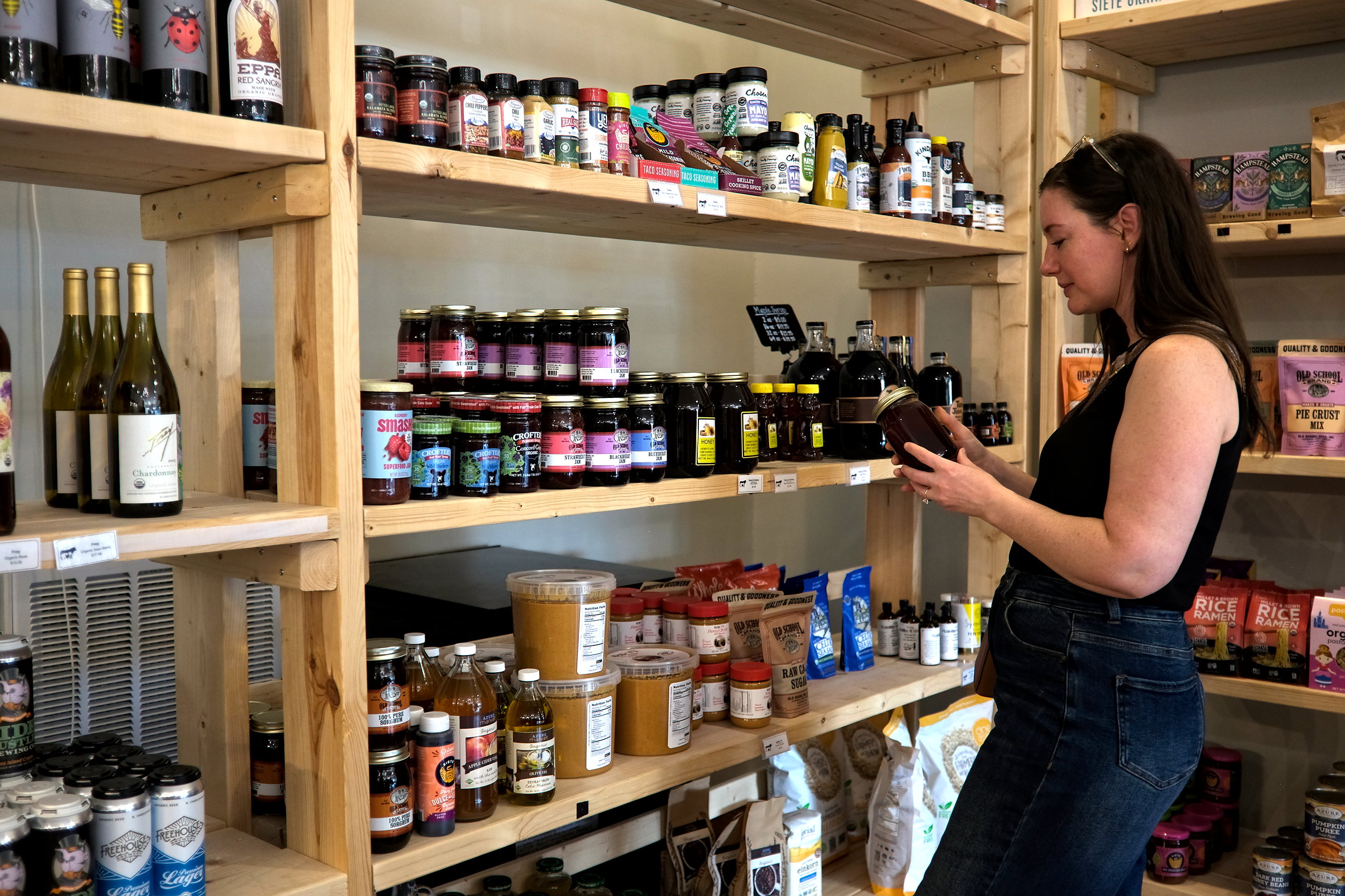 Alyssa looks at a jar of honey at Sanitary Market in Laurens, SC