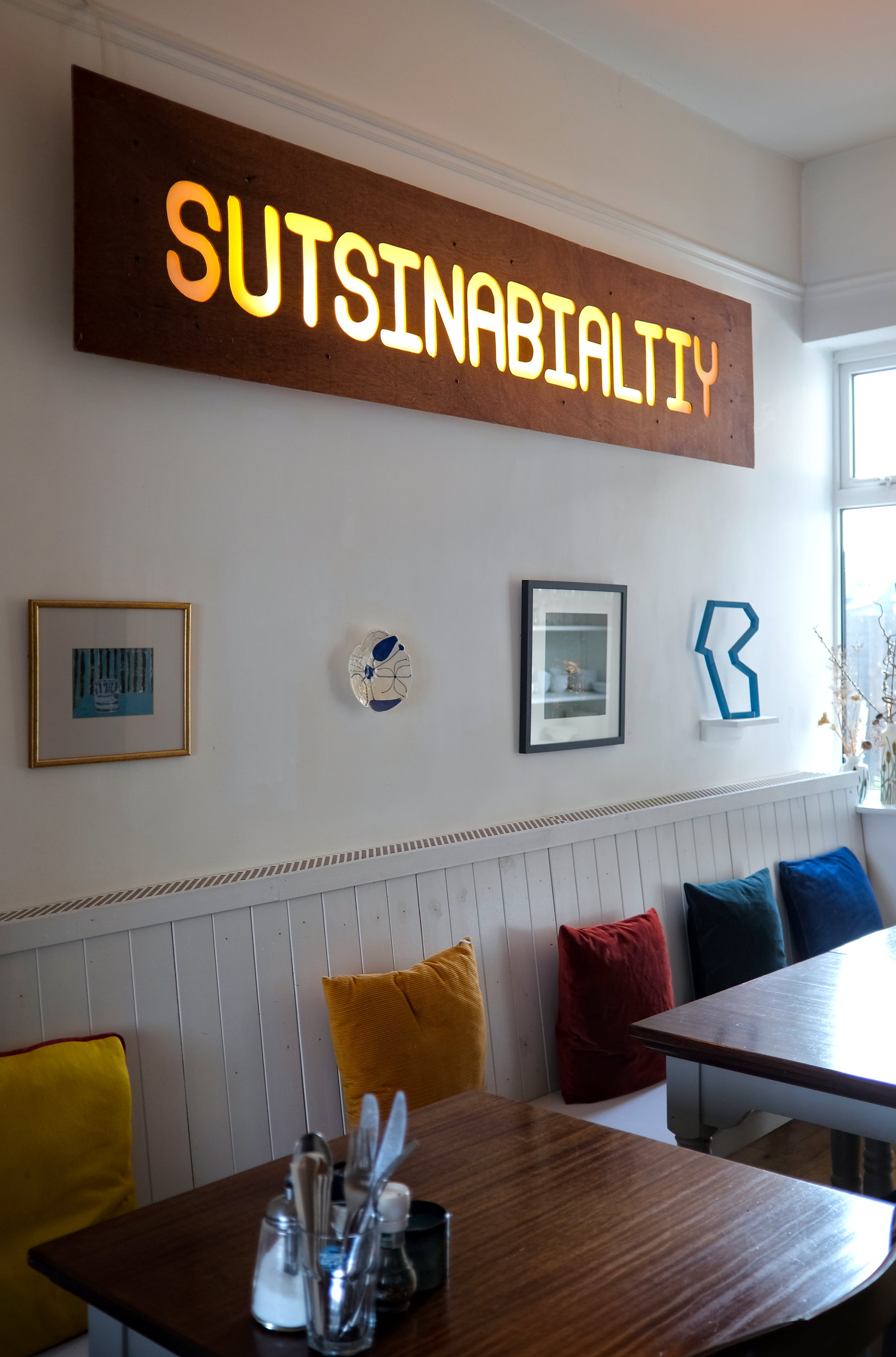 Artwork in the breakfast room at The Stop, including a large piece that reads "sutsinabialtiy"