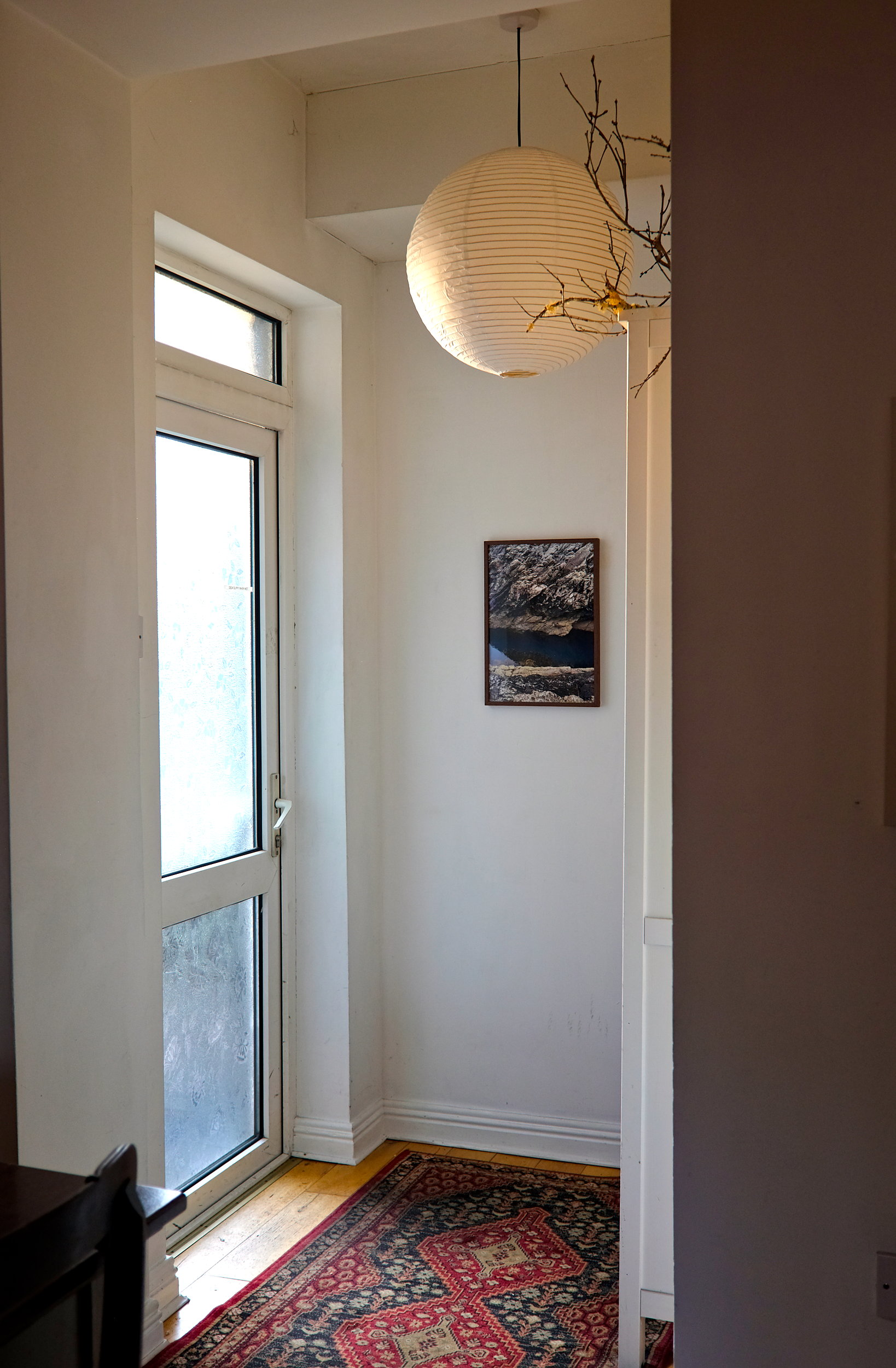 The doorway at The Stop in Galway, with a round paper light fixture and daylight streaming through the door
