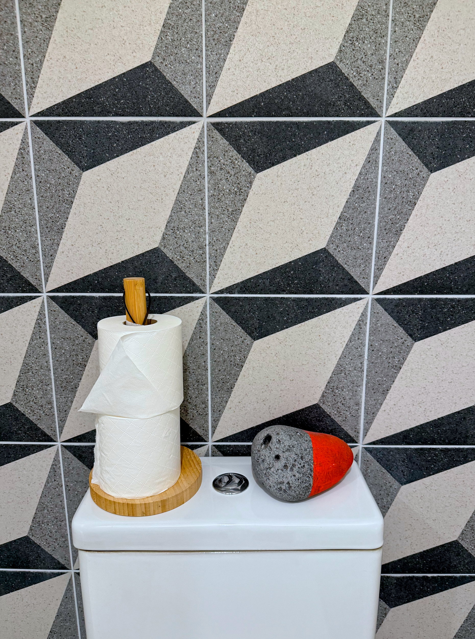 Bathroom view at The Stop Galway showing a tidy toilet setup with two extra toilet rolls and a hand-painted rock adding a playful decorative touch.