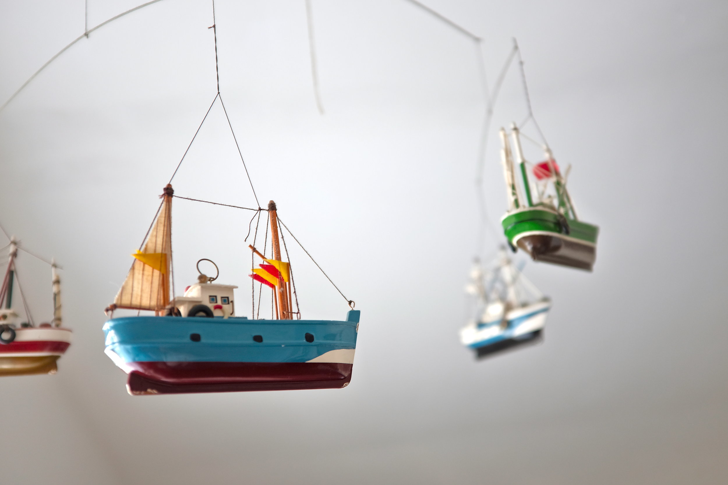 A mobile with ships hangs from the ceiling at The Stop