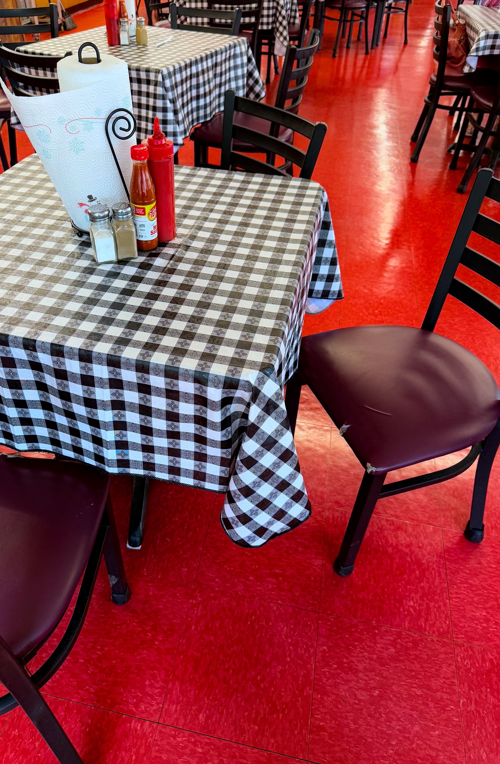 The interior of Wilson's Curb Market, with red floors and tables with gingham tablecloths